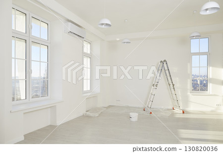 Interior of newly renovated apartment with white walls, new windows, ladder and paint can 130820036