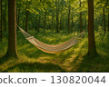 Hammock suspended between trees in a serene forest setting with dappled sunlight filtering through leaves 130820044