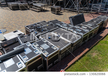 Boxes with sound and lighting equipment and cables near a concert stage during setup. 130820066