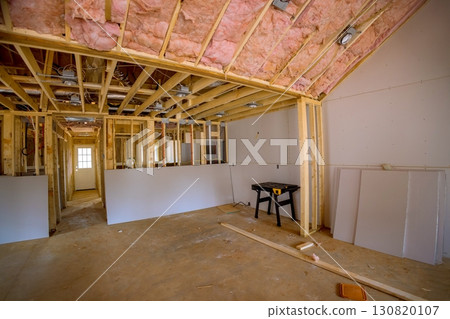 Construction team works on home interior renovation with exposed wood, insulation celling background. 130820107