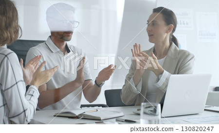 Professional team applauding, celebrating collaborative success and recognizing outstanding performance during corporate meeting, expressing shared workplace achievement. Business people concept 130820247