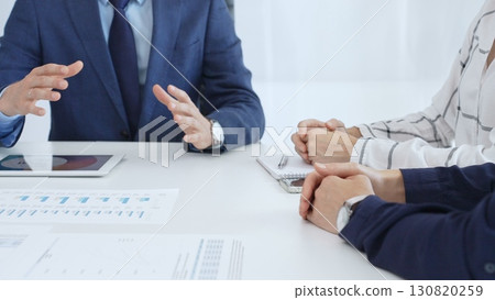Business professionals discussing financial charts on tablet, collaborating closely while reviewing project data in modern corporate workspace Business professionals discussing financial charts on tablet, collaborating closely while reviewing project data in modern corporate workspace 130820259
