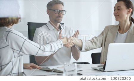 Businesswomen partners are shaking hands after successful negotiation, colleagues clapping, celebrating agreement in modern office headset. Handshake concept Businesswomen partners are shaking hands after successful negotiation, colleagues clapping, celebrating agreement in modern office headset. Handshake concept 130820260