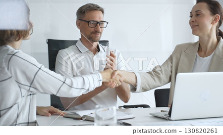 Businesswomen partners are shaking hands after successful negotiation, colleagues clapping, celebrating agreement in modern office headset. Handshake concept Businesswomen partners are shaking hands after successful negotiation, colleagues clapping, celebrating agreement in modern office headset. Handshake concept 130820261