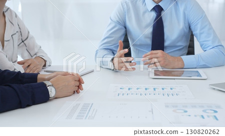 Business people reviewing financial metrics on digital screens, collaborating strategically while examining charts and graphs in office Business people reviewing financial metrics on digital screens, collaborating strategically while examining charts and graphs in office 130820262