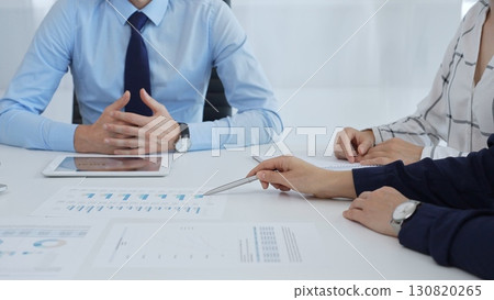Business professionals discussing financial charts on tablet, collaborating closely while reviewing project data in modern corporate workspace Business professionals discussing financial charts on tablet, collaborating closely while reviewing project data in modern corporate workspace 130820265