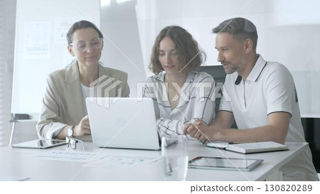 Business professionals reviewing marketing analytics on laptops, working together strategically in contemporary workplace with minimalist interior design and collaborative atmosphere Business professionals reviewing marketing analytics on laptops, working together strategically in contemporary workplace with minimalist interior design and collaborative atmosphere 130820289