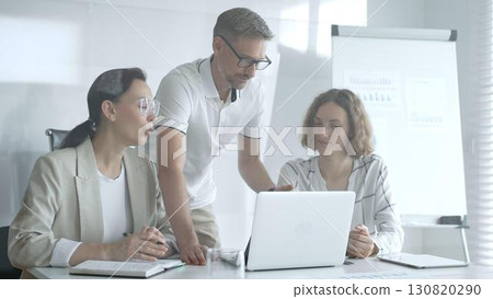 Business team collaborating and analyzing data on a laptop during a productive meeting in a modern office, fostering teamwork and strategic decision making Business team collaborating and analyzing data on a laptop during a productive meeting in a modern office, fostering teamwork and strategic decision making 130820290
