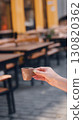 Hand holding a coffee cup in a cozy cafe with blurred background. 130820362