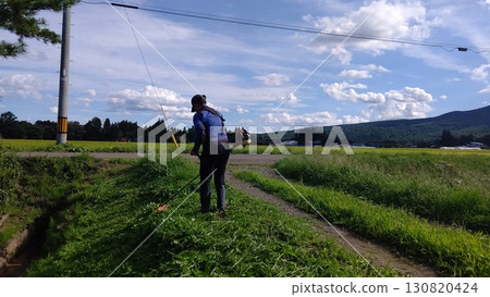 一名婦女在農場道路上割草 一名婦女在農場道路上割草 130820424