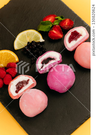 Colorful mochi ice cream with fruity filling on slate board with fresh berries and citrus Colorful mochi ice cream with fruity filling on slate board with fresh berries and citrus 130820624