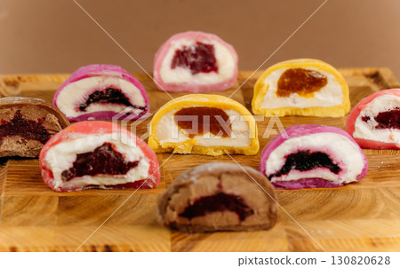 Assorted colorful mochi ice cream halves on wooden board, close-up view, studio lighting Assorted colorful mochi ice cream halves on wooden board, close-up view, studio lighting 130820628