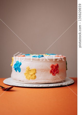 Handmade celebration cake with colorful floral buttercream decorations on orange background Handmade celebration cake with colorful floral buttercream decorations on orange background 130820659