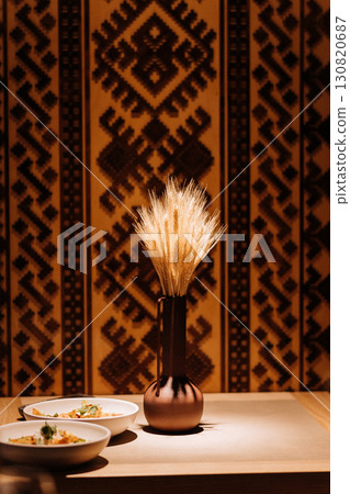 Traditional wheat bouquet in a clay vase with ethnic background and warm cozy lighting 130820687
