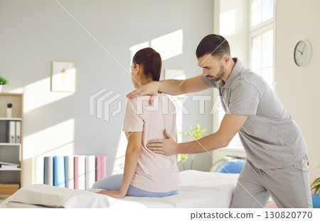 Rehabilitation, woman back, spine, shoulder massage, physical therapy by professional male nurse 130820770