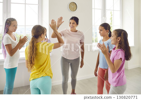 Happy female choreographer rejoicing the success of her students girls in dance training Happy female choreographer rejoicing the success of her students girls in dance training 130820771