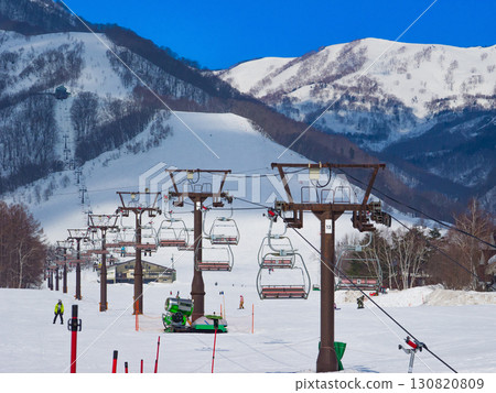 Rows of chairlifts on a vast slope and snowy mountain scenery (Tsugaike Kogen, Hakuba, Nagano Prefecture) 130820809