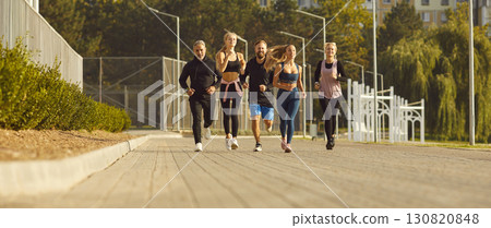 A group of happy athletes running down the street 130820848