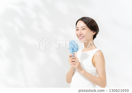 A woman who cools down with a handy fan A woman who cools down with a handy fan 130821050