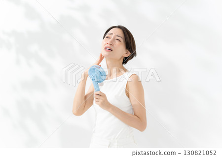 A woman who cools down with a handy fan 130821052