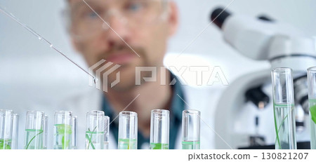 Man researcher with safety glasses is working with lab tubes using a pipette in laboratory, close-up of lab equipment. Science and medicine Man researcher with safety glasses is working with lab tubes using a pipette in laboratory, close-up of lab equipment. Science and medicine 130821207