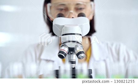 Woman scientist using microscope in laboratory. Microbiology science concept Woman scientist using microscope in laboratory. Microbiology science concept 130821255