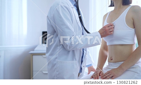 Doctor and patient. Physician is using stethoscope examining woman lungs in clinic cabinet. Medicine and health care Doctor and patient. Physician is using stethoscope examining woman lungs in clinic cabinet. Medicine and health care 130821262