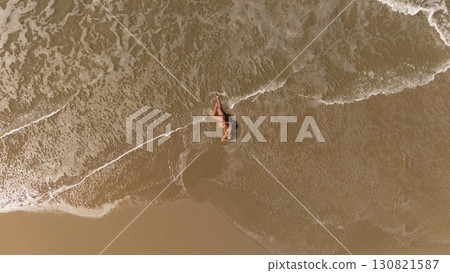 Pregnant Woman Relaxing by the Ocean Aerial Beach Photography 130821587