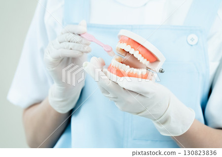Dental hygienist giving tooth brushing instructions Dental hygienist giving tooth brushing instructions 130823836