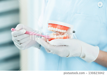 Dental hygienist giving tooth brushing instructions Dental hygienist giving tooth brushing instructions 130823842