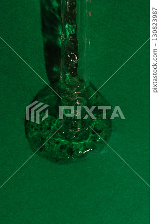 Skincare serum dripping from glass dropper macro view 130823987