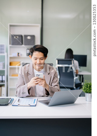 Young businessman working with laptop, tablet and taking notes on the paper at office Young businessman working with laptop, tablet and taking notes on the paper at office 130825353
