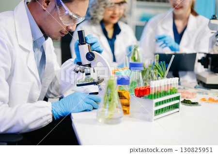 Food scientists in lab coats, testing samples, and analyzing food safety and quality in a modern laboratory 130825951