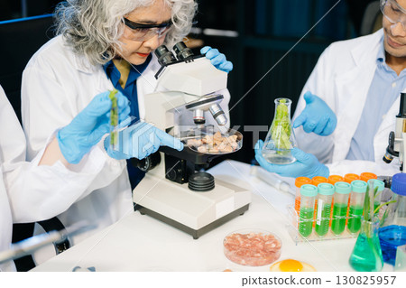 Food scientists in lab coats, testing samples, and analyzing food safety and quality in a modern laboratory Food scientists in lab coats, testing samples, and analyzing food safety and quality in a modern laboratory 130825957