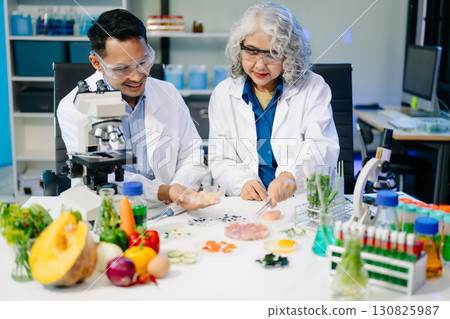 Food scientists in lab coats, testing samples, and analyzing food safety and quality in a modern laboratory Food scientists in lab coats, testing samples, and analyzing food safety and quality in a modern laboratory 130825987