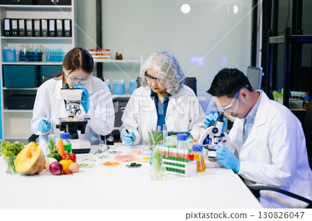 Food scientists in lab coats, testing samples, and analyzing food safety and quality in a modern laboratory 130826047