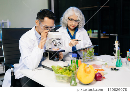 Food scientists in lab coats, testing samples, and analyzing food safety and quality in a modern laboratory 130826078