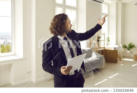 Confident male real estate agent conducts inspection in apartment that is for sale. Confident male real estate agent conducts inspection in apartment that is for sale. 130826646
