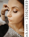 Makeup artist applying mascara to eyelashes. Close-up, vertical view 130826839