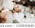Mascara. Makeup artist takes out brush with mascara. Makeup concept, close-up 130826840
