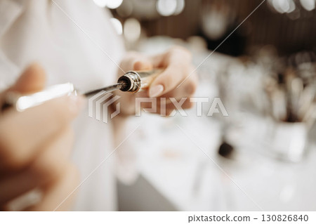 Mascara. Makeup artist takes out brush with mascara. Makeup concept, close-up Mascara. Makeup artist takes out brush with mascara. Makeup concept, close-up 130826840
