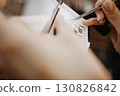 Eyelash extensions. Hand of makeup artist takes eyelashes with tweezers for subsequent gluing of extensions 130826842