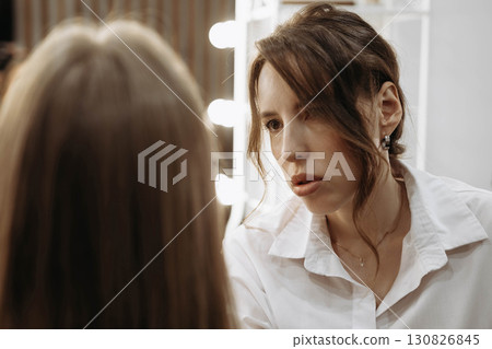 Makeup artist working on creating look for model. Focused look of makeup artist Makeup artist working on creating look for model. Focused look of makeup artist 130826845