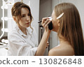 Makeup artist applies eye makeup to model 130826848