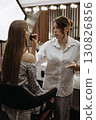 Makeup artist works with model to create an image. Preparing model skin 130826856