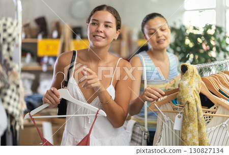 Two joyful women looking for fashionable clothes in clothing boutique 130827134