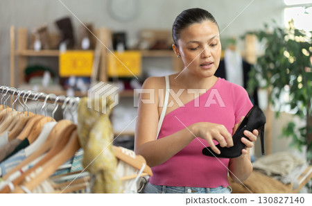 Young Asian woman choosing heels in clothing store 130827140
