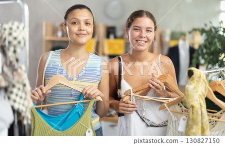 Near rack, female friends buy summer clothes, choose some items 130827150