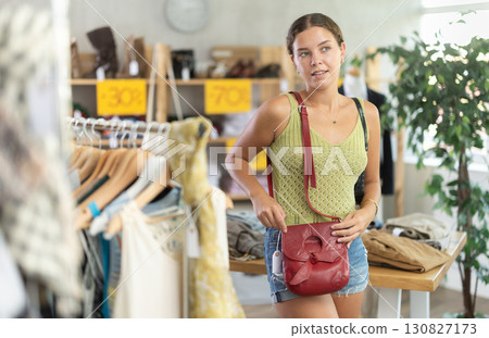 Young woman choosing a fashionable handbag in boutique Young woman choosing a fashionable handbag in boutique 130827173