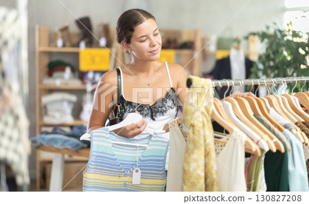 Woman customer turn over and choose something clothing for summer in store Woman customer turn over and choose something clothing for summer in store 130827208